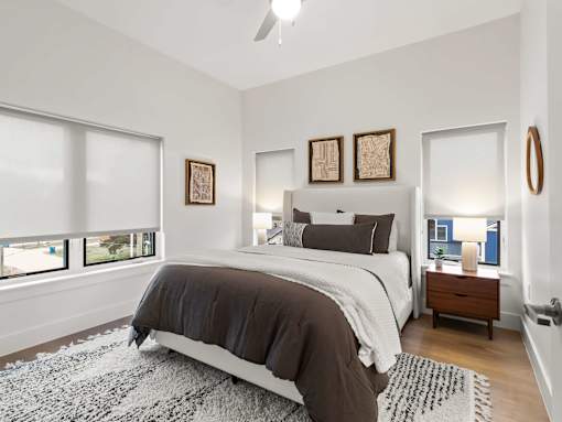 A bedroom with a large bed and a ceiling fan.