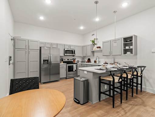 A kitchen with a table and chairs and a fridge.