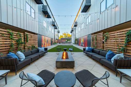 A patio with a fire pit and seating area.