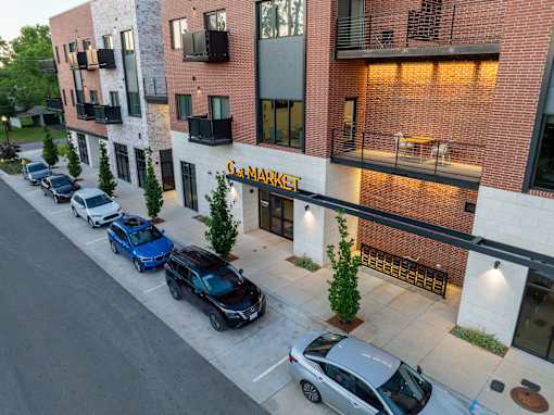 A street view of a building with cars parked in front of it.