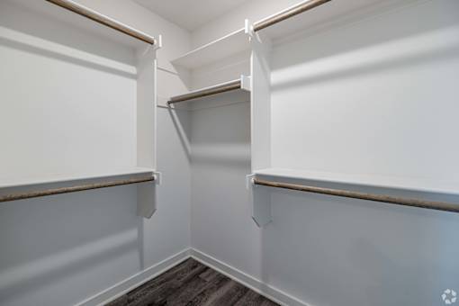 A white pantry with a wood shelf and a recycling symbol on the floor.