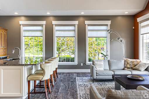 A well-lit, modern kitchen with a bar area and a couch.