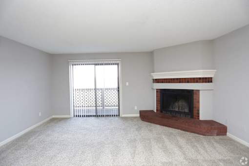 A living room with a fireplace and sliding glass doors.