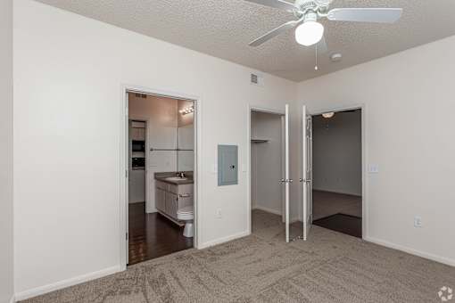 A room with a ceiling fan and a carpeted floor.