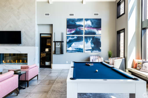 an open living room with a pool table and a fireplace  at Waterside Residences on Quivira, Lenexa, 66215