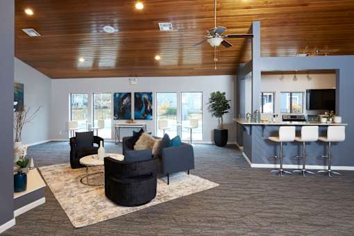 A modern living room with a kitchen in the background.