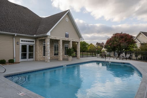Pool with chairs and clubhouse in view