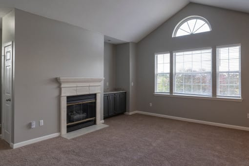a living room with a fireplace and two windows
