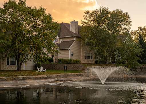 A house with a fountain in front of it.