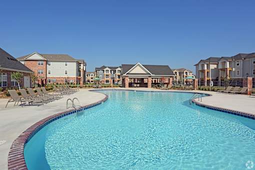 A large swimming pool in front of apartment buildings.