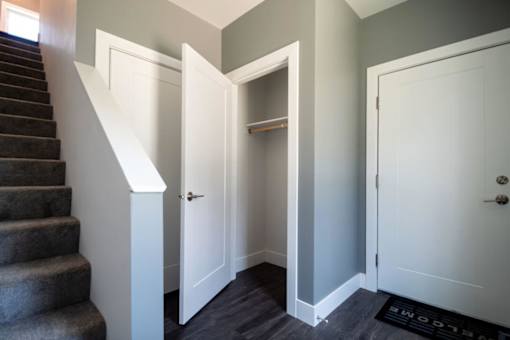 A hallway with a staircase and two doors.