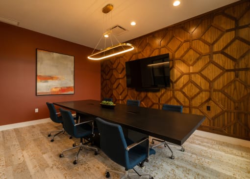 a conference room with a table and chairs and a tv  at The Clearing at ONE28, Olathe, KS