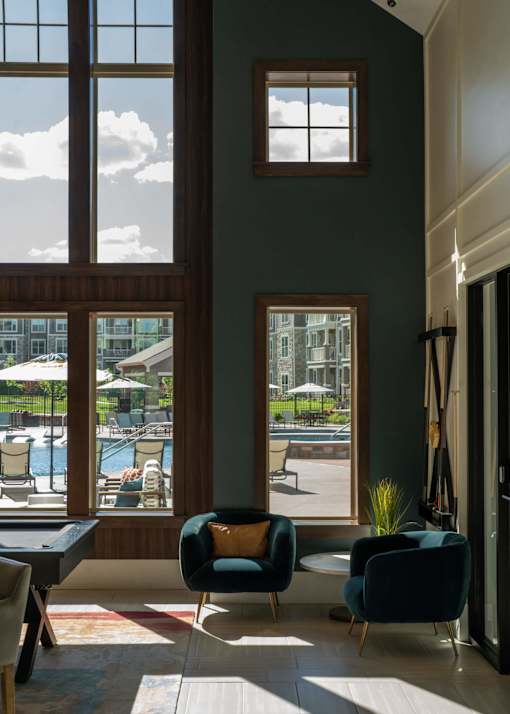 a living room with a view of a swimming pool at The Clearing at ONE28, Olathe, KS