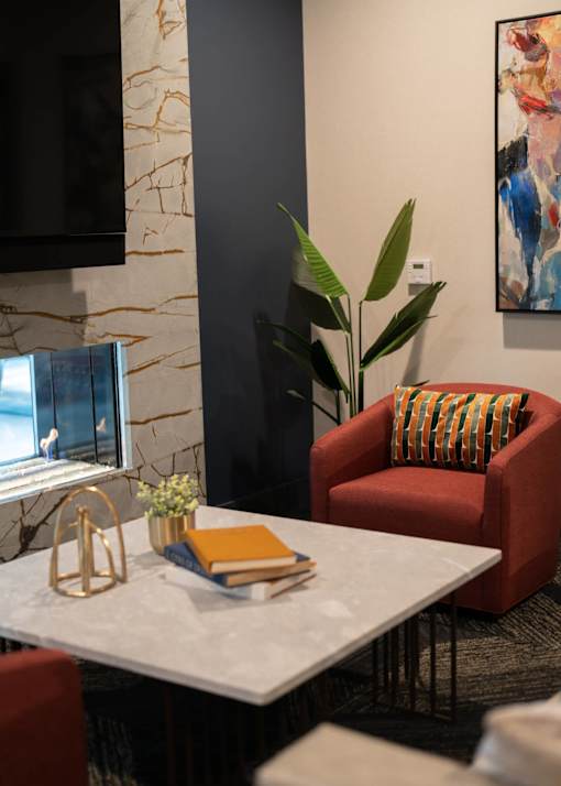 a living room with a table and chairs and a computer at The Clearing at ONE28, Olathe, KS