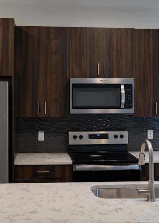 a kitchen with a stove and a microwave at The Clearing at ONE28, Olathe, Kansas