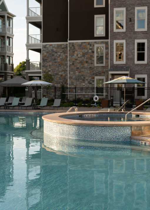a large swimming pool with a building in the background at The Clearing at ONE28, Olathe, KS