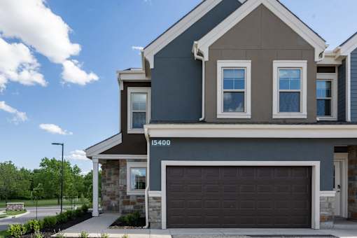 a home with a garage door in front of it at The Clearing at ONE28, Olathe, KS