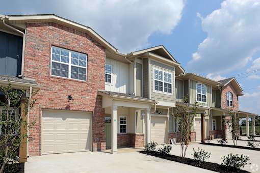 A row of houses with garages and driveways.