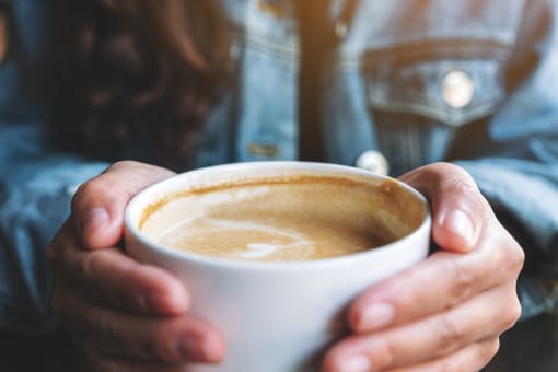 a woman holding a cup of coffee at The Crest at South Point, McDonough