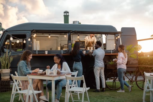 people eating at a table in front of a food truck at The Crest at South Point, McDonough, GA