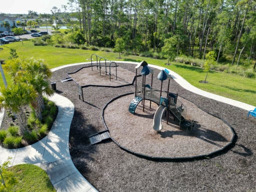 a playground is shown in a park with trees at The Crest at Laurel Canyon Apartments, Florida
