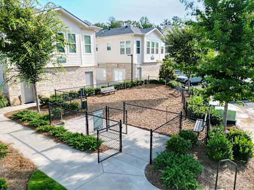 Fenced dog park with bench and landscaping at The Crest at Acworth Apartments, Acworth, 30102