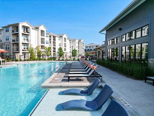 Resort style pool with lounge chairs and tanning ledge at The Crest at Acworth Apartments, Acworth, Georgia