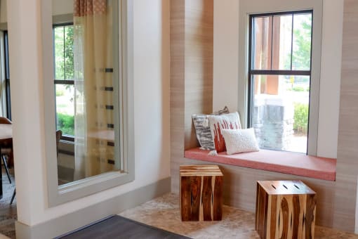 a window seat with a cushion and two wooden stools at The Crest at Laurel Canyon Apartments, Canton, GA, 30114