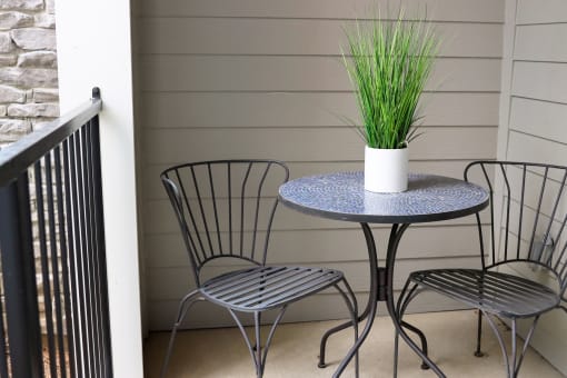 a patio with a table and three chairs at The Crest at Laurel Canyon Apartments, Canton, 30114