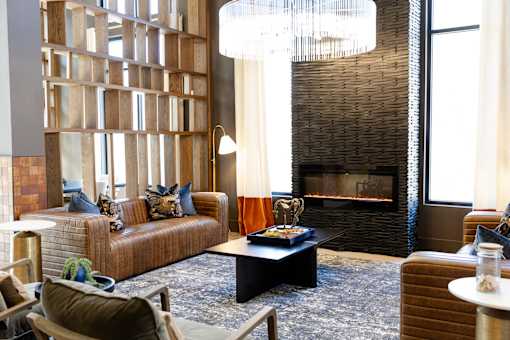 modern living room with a fireplace and a large window at District on the Etowah Apartments, Canton, GA