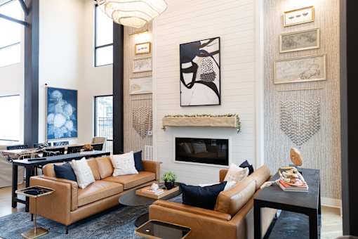 A living room with a fireplace and a painting above it at The Crest at South Point Apartments, Georgia, 30253
