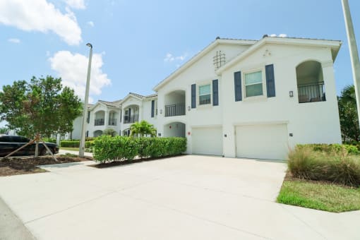 a large white house with a garage at The Crest at Naples, Naples, FL, 34113
