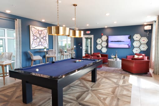 a spacious game room with a pool table and couches at The Crest at Laurel Canyon Apartments, Naples, FL, 34113