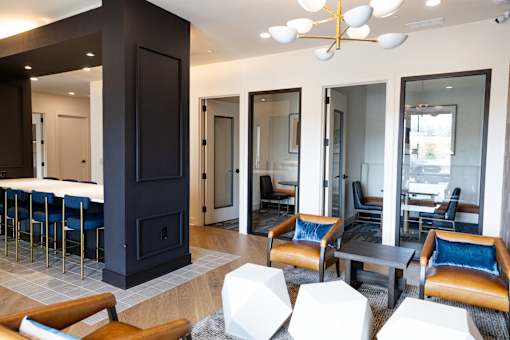 A modern living room with a dark wood fireplace and blue chairs.