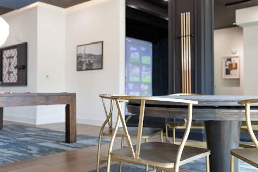 A dining table with chairs and a bench in a room. at The Crest at South Point Apartments, Georgia, 30253