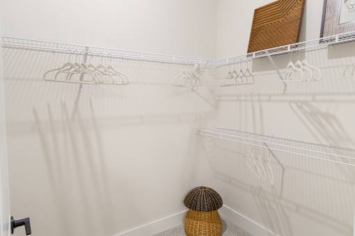 A white closet with a hat on the floor.