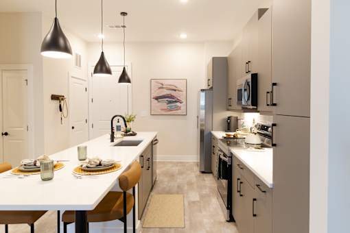 A modern kitchen with a dining table set for two.