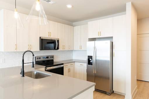 Versatile modern kitchen with granite counter at District on the Etowah Apartments, Canton Georgia