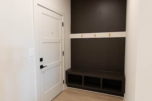 A white door is on the left of a dark brown wall. A white door is on the left of a dark brown wall.