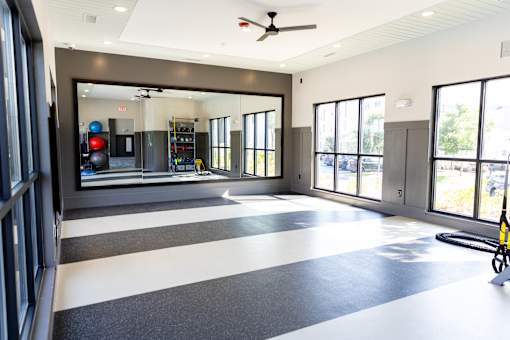 Fitness studio with mirrored wall and rubber flooring at The Crest at Acworth Apartments, Acworth, 30102