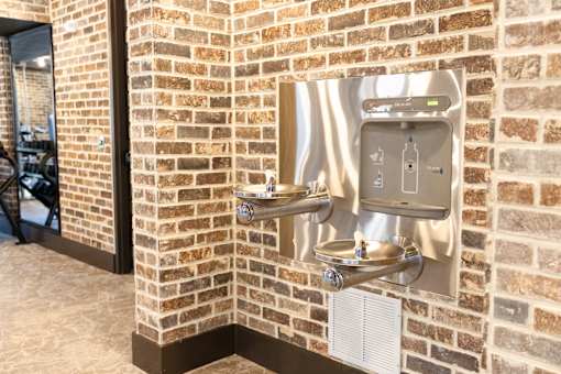 brick wall with a water dispenser at District on the Etowah Apartments, Georgia, 30114