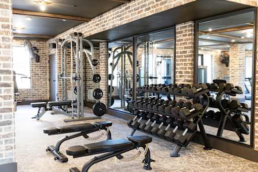 gym with a brick wall at District on the Etowah Apartments, Georgia