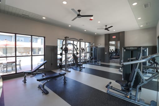 a gym with weights and other exercise equipment and windows at The Crest at Acworth, Georgia, 30102