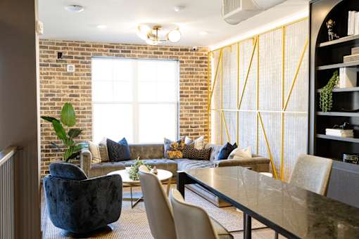 living room with a brick wall and a couch at District on the Etowah Apartments, Canton