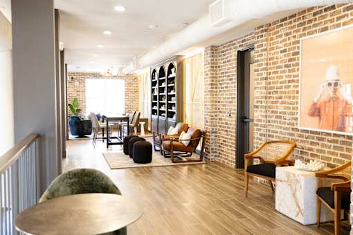 room with a brick wall and a painting of a person at District on the Etowah Apartments, Canton Georgia
