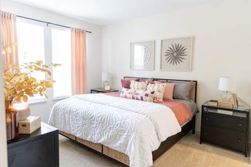 Bedroom with pink accents and neutral decor at The Crest at Acworth Apartments, Acworth, GA