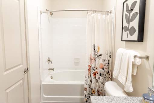 Bathroom with tub shower combo and floral curtain at The Crest at Acworth Apartments, Acworth, 30102