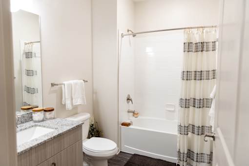 Bathroom with white subway tile and striped shower curtain at The Crest at Acworth Apartments, Acworth, GA