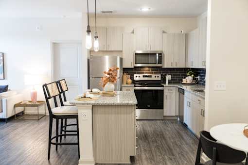 Modern kitchen with island seating and stainless appliances at The Crest at Acworth Apartments, Acworth, 30102