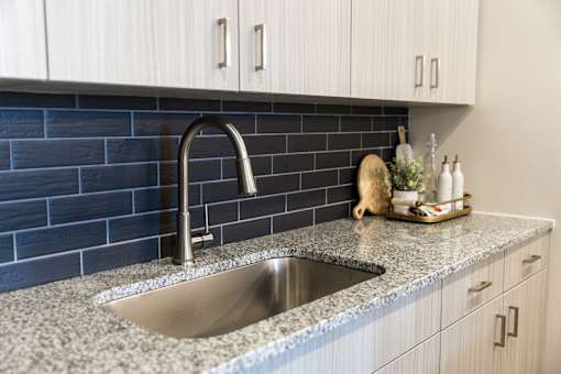 Modern kitchen sink with dark tile backsplash at The Crest at Acworth Apartments, Acworth